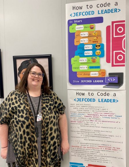 Charlsie beside the How to Code a JEFCOED Leader poster series she designed: leadership traits written as code